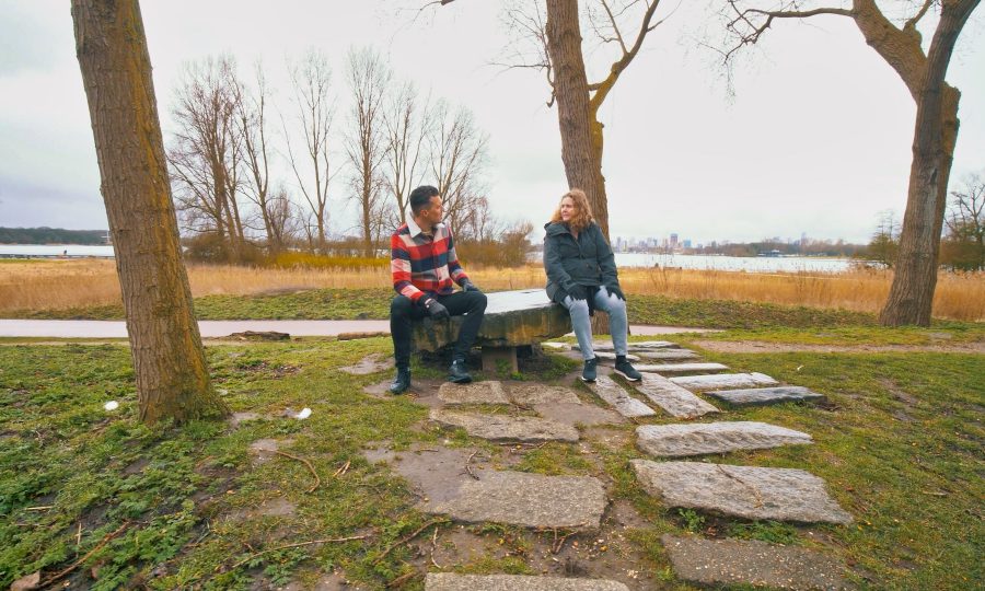 Two people sitting beside a lake doing an interview