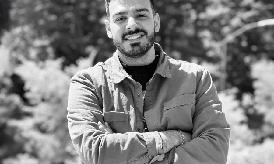 A picture if Nima Salami smiling with his arms folded